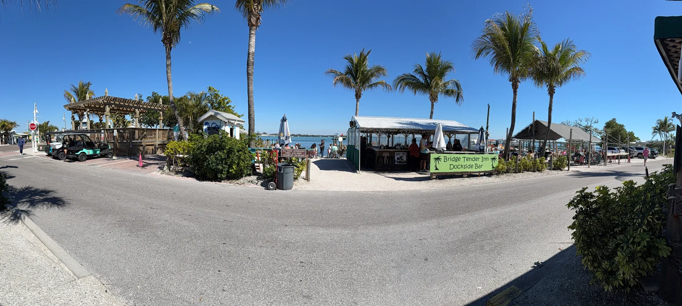 Palm-lined waterfront street and restaurants