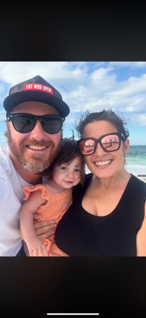 John and Kristen Orr with their daughter at the beach