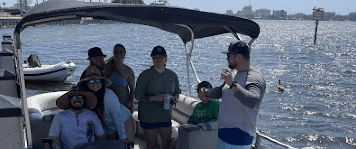 a group of people in a deck boat on a body of water