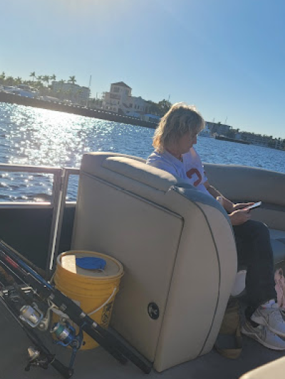 a woman sitting in a deck boat on a body of water